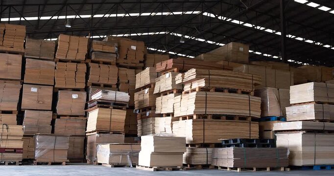 Background of neatly stacked square wooden beams in a lumberyard, wood factory. Close up of texture and ends of sawn timber blocks arranged in bundles. Rows of square cut wood planks stacked.