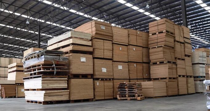 Background of neatly stacked square wooden beams in a lumberyard, wood factory. Close up of texture and ends of sawn timber blocks arranged in bundles. Rows of square cut wood planks stacked.
