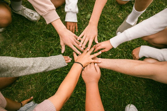 Directly above shot of hands stacked together to show teamwork and unity during summer camp
