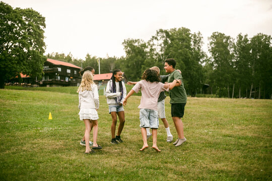 Group of diverse friends jumping and cheering after fun game at summer camp