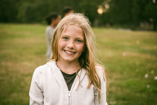 Portrait of smiling girl with blond hair at park