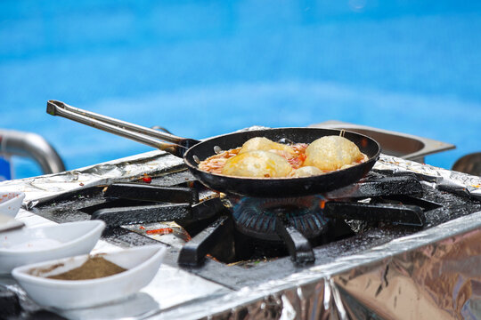 Preparing breakfast for tourists hotel pool, outdoor service, resort hospitality, summer breakfast by the water.