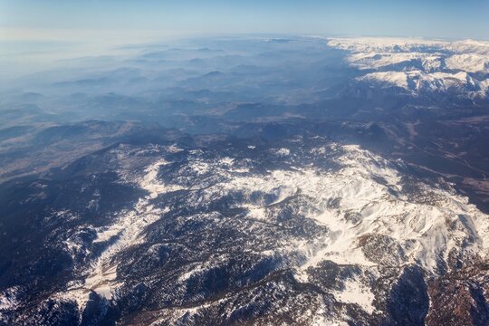 Aerial view of the snow-capped Taurus Mountains featuring rugged peaks and vast terrain in Cukurova, Turkey.