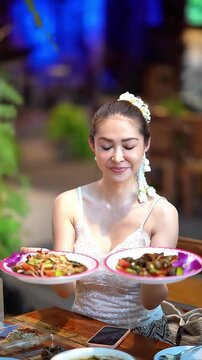Slow motion of happy young Thai woman in traditional dress with flower crown enjoying delicious food, culture and lifestyle stock video.