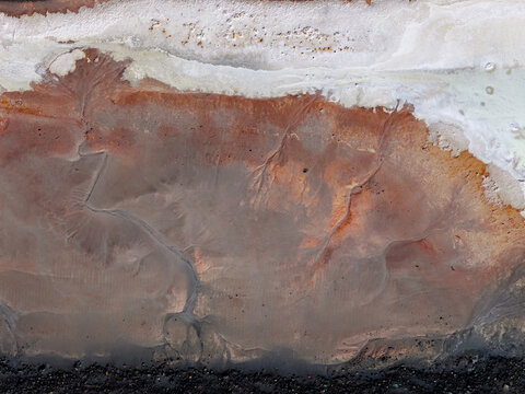 Aerial view of wastewater evaporation ponds by the Great Salt Lake with crystalized salt and crusted salty ground in Ogden, Utah, United States.