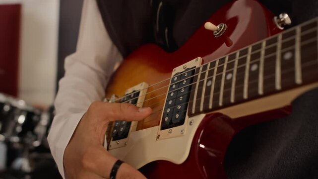 Caucasian teenage musician playing electric guitar during band rehearsal in music studio. Perfect for creative arts education, youth hobbies, music lessons, audio school or entertainment campaigns