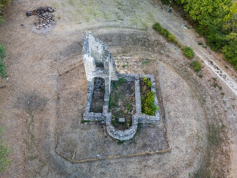 Aerial view of the medieval Csabdi church ruins, with surviving stone walls and an arched apse, in an open rural clearing surrounded by trees in Csabdi, Hungary.