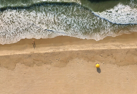 A couple enjoys a morning walk at sunrise on Carolina Beach, near Wilmington, North Carolina in New Hanover County