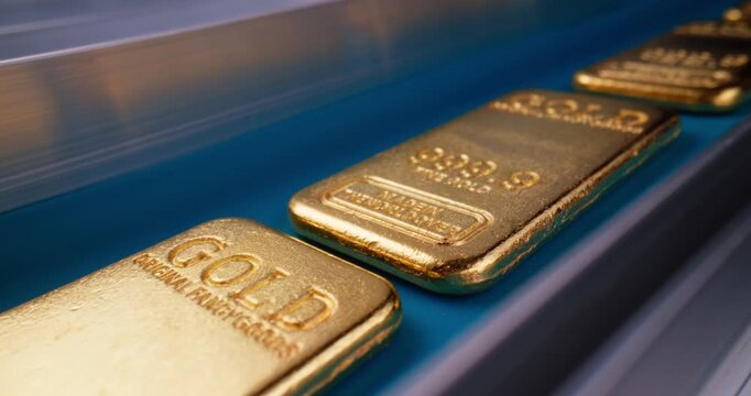 Tracking shot of gold bars sliding along conveyor belt in mining factory production line, probe view.