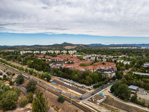 Aerial view of residential neighborhoods, apartment blocks and railway infrastructure in Obuda, Budapest, Hungary, with the Buda Hills and Pilis Mountains beyond.