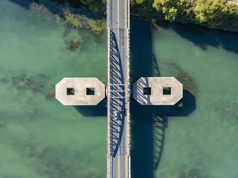 Aerial view of Ura e re e Bunes crossing the turquoise waters of the Buna River with concrete piers casting long shadows in Shkoder, Qarku i Shkodres, Albania.