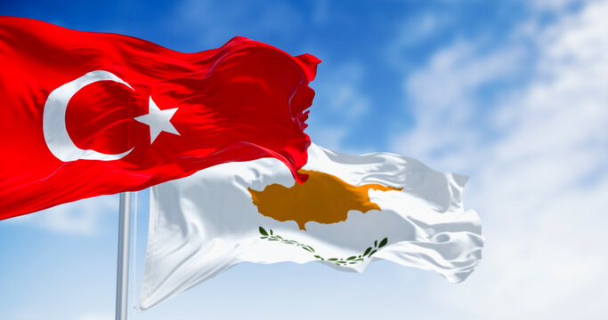 Turkish and cypriot national flags waving in the wind on a clear day