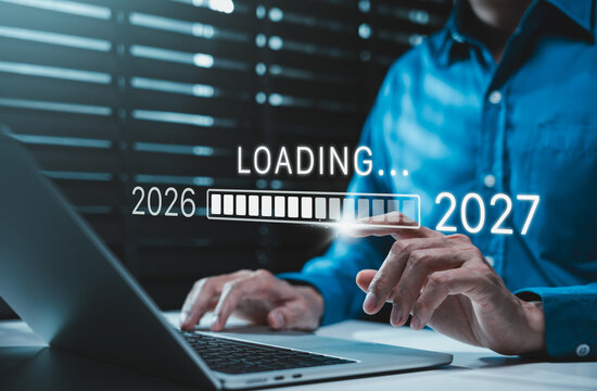Progress and transition from 2026 to 2027 concept. Businessman person pointing to loading bar transitioning from 2026 to 2027, progress, future planning, new year goals, annual plan, business growth