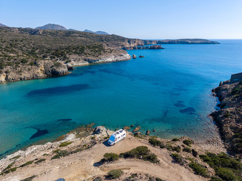 Stunning coastal view at Agathia Beach in Milos, Greece with a van on the shore