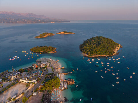 Aerial view of the Ksamil Islands featuring turquoise waters, sandy beaches, boats anchored in the bay, and lush green vegetation at Ksamil, Vlore County, Albania.