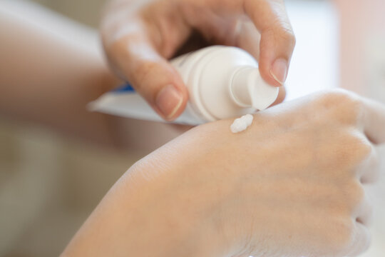Close-up hands of woman using moisturizer cream applying hand