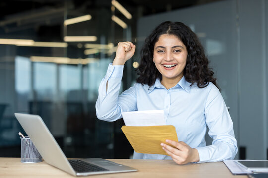 Happy businesswoman celebrating success reading good news letter