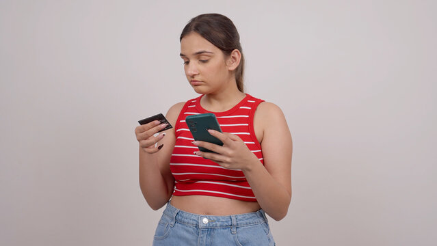 Confused Young Indian Teenager Entering Credit Card Details on a Smartphone