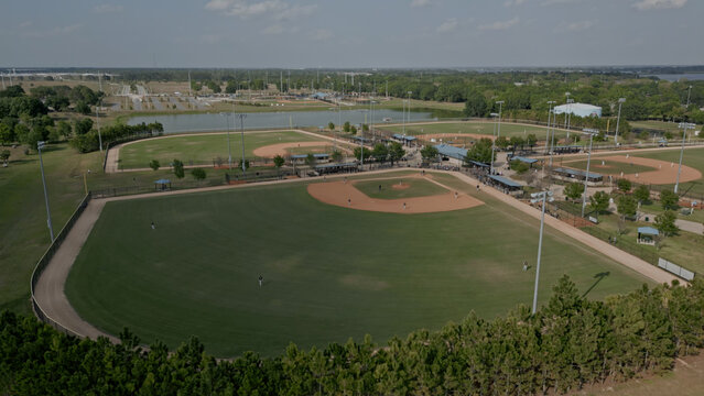 Aerial view of the baseball field complex featuring multiple diamonds, manicured grass, dirt infields, and surrounding trees in Polk City, Florida, United States.