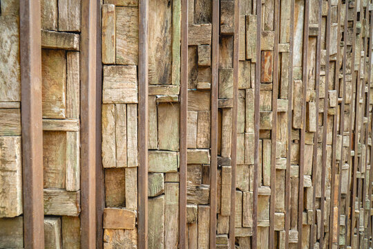 Vertical bamboo wall panel with weathered strips arranged closely together, creating a rustic natural texture and repetitive linear pattern.