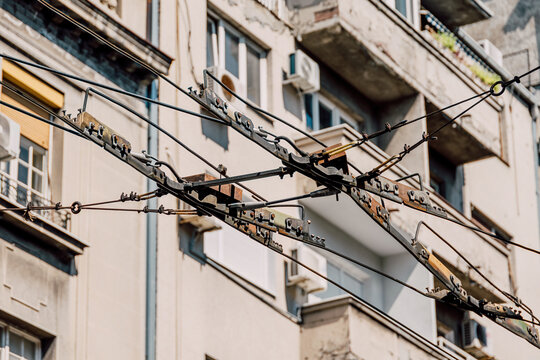 Urban residential building facade in Belgrade, Serbia, showing numerous tangled electrical wires and trolleybus lines