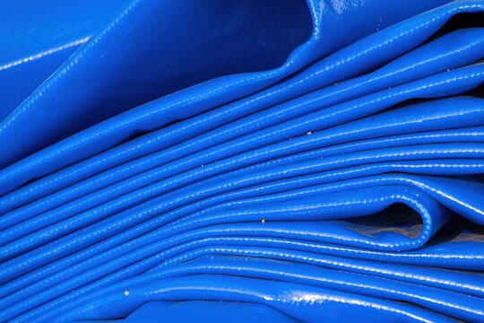 Title:
Folded blue woven tarpaulin with textured waterproof surface