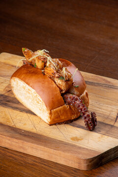 Shrimp and octopus seafood sandwich on a wooden board