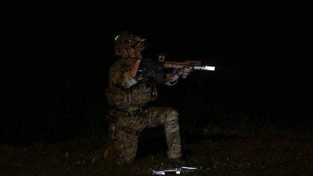 Soldier in tactical gear prepares to engage during nighttime