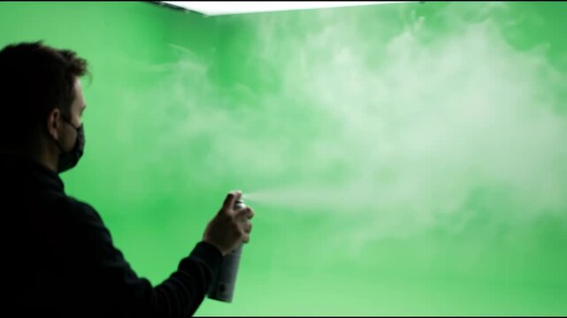 Silky white aerosol spray lingering in a bright chroma green environment creating a smooth and even optical haze for compositing.