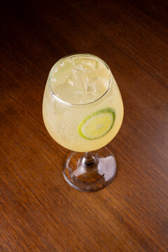 Glass of limoncello spritz with gin, isolated on a wooden table, top-down angle.