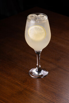 Glass of limoncello spritz isolated on a wooden table.