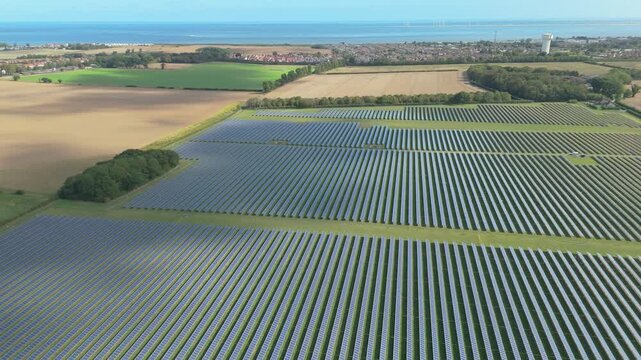 A aerial drone pull back movement at a 13.9MW solar photovoltaic farm on the Norfolk coast in the UK