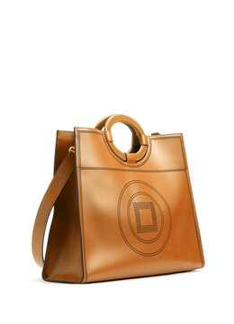 Yellow brown leather handbag with large circular handle isolated on white background