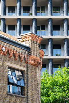 Historic brick facade beneath modern balconies in The City in London, with layered urban architecture combining historic brick facade and modern balconies