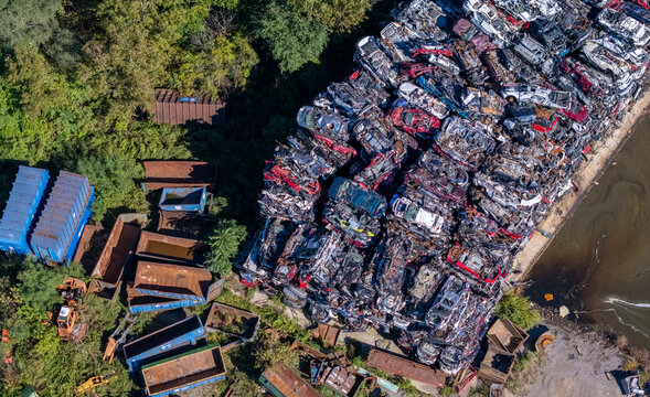 Aerial view of a scrap metal facility with large stacks of crushed cars and polluted water in Kalamazoo, Michigan, United States.