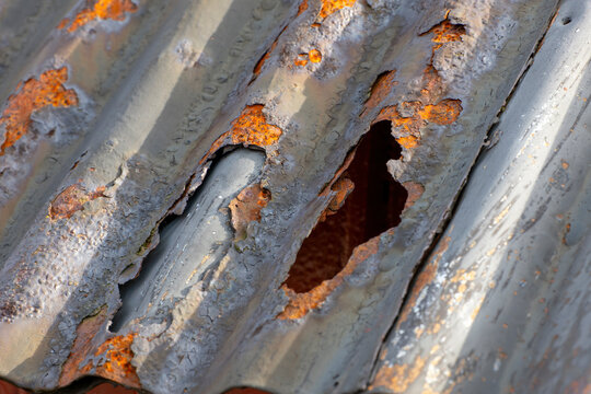 Rusty corrugated metal roof on a red wooden house