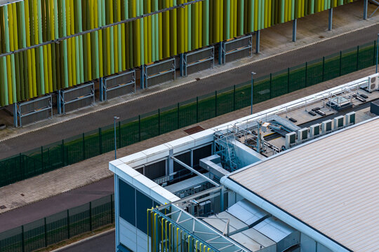 Aerial view of the Kao Data campus, featuring modern industrial architecture, green and yellow facades, rooftop HVAC units, and perimeter fencing in Harlow, England, United Kingdom.