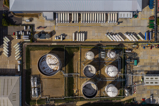 Aerial view of Hemel Hempstead Industrial Estate featuring a large warehouse with numerous loading bays and several circular industrial storage tanks in London, England, United Kingdom.