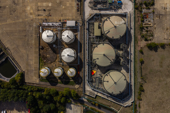 Aerial view of industrial storage tanks at Hemel Hempstead Industrial Estate featuring large circular containers, pipelines, and paved surfaces in Hemel Hempstead, England, United Kingdom.