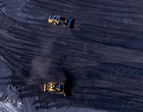 Aerial view of heavy equipment operating on a large coal pile at a power plant in West Olive, Michigan, United States.