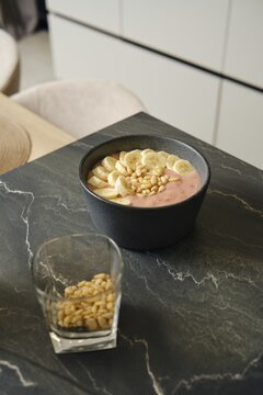 Delicious banana-strawberry smoothie served with pine nuts in a modern kitchen setting