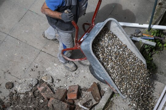 Construction worker empties wheelbarrow with gravel, Stuttgart, Baden-W&uuml;rttemberg