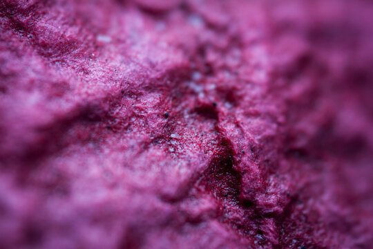 Extreme close up of purple handmade paper clay with a structure and rough texture. Paper recycling. Selective soft focus, shallow depth of field.