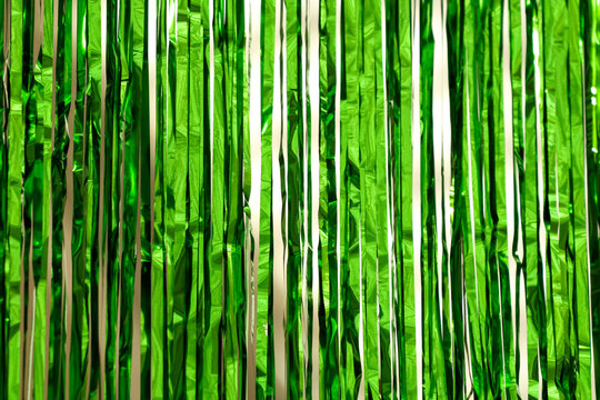 Vibrant green metallic tinsel hangs vertically