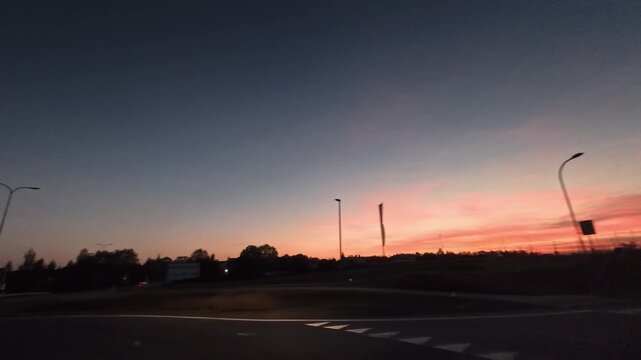 Timelapse of cars Driving On Curved Road At Sunset Twilight With Streetlights And Evening Sky