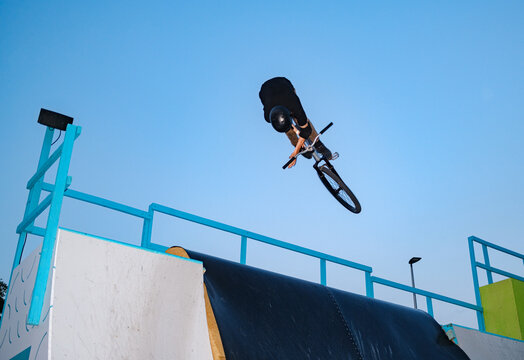 Rider In Helmet Trains Bike Stunts In Skate Park