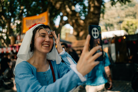 Woman Takes Selfie at Festival During Sunny Day