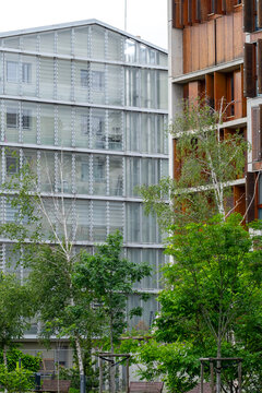 Urban green space between modern buildings in Europe, with trees, landscaping and residential architecture creating a dense city setting