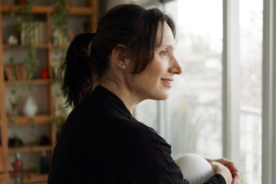 Woman Looking out the Window With a Thoughtful Expression