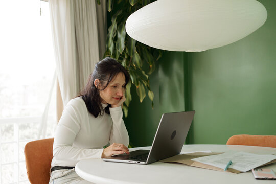 Woman Working on Laptop at Home Office in Modern Setting